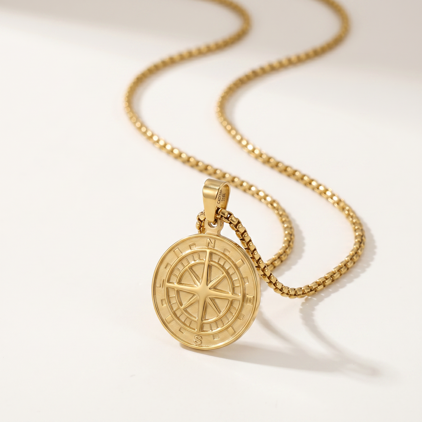 Close-up of the engraved compass medallion and box chain