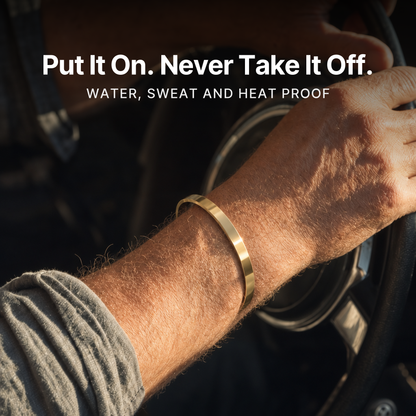 887Seven Meridian Cuff in 18K gold worn with a hand on a steering wheel. Put it on, never take it off.