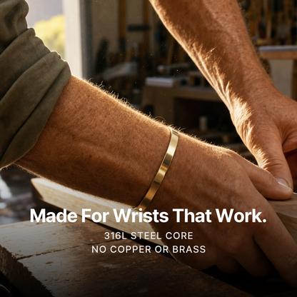 887Seven Meridian Cuff in 18K gold worn at a workshop bench. Made for wrists that work. 316L steel core, no copper or brass.