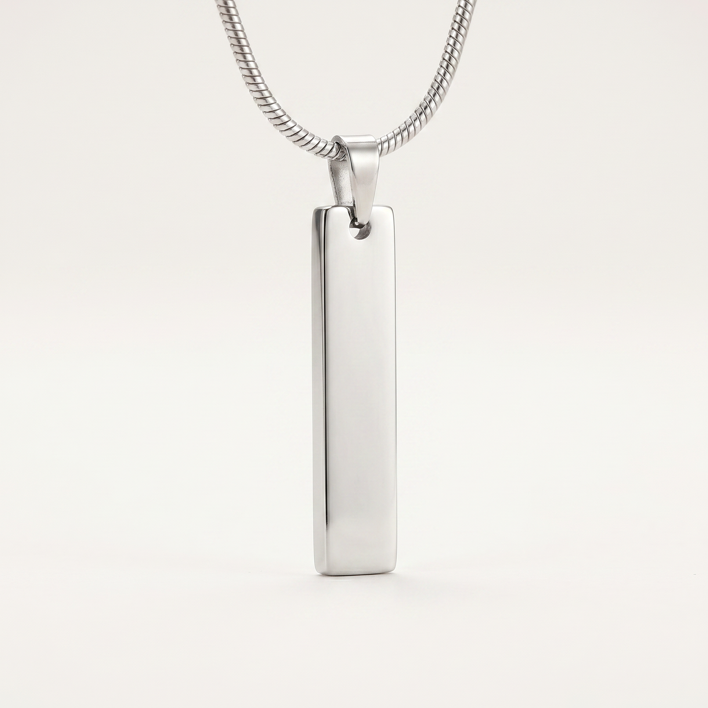 Close-up of the slim silver bar pendant
