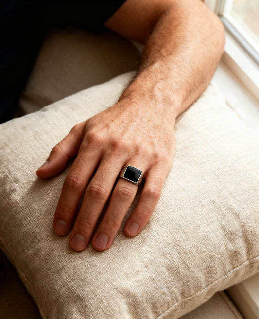 Square onyx signet ring worn on the hand