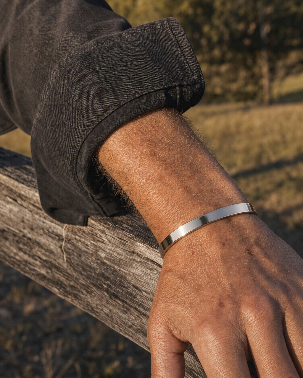 887Seven Meridian Cuff in polished 316L steel, 6mm flat band, worn outdoors with a forearm on a fence rail