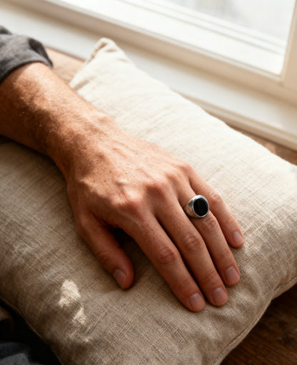 Round onyx signet ring worn on the hand