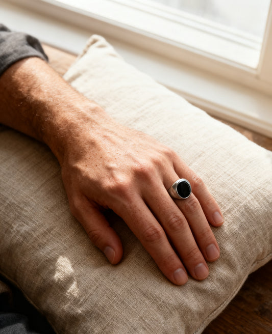 Round onyx signet ring worn on the hand