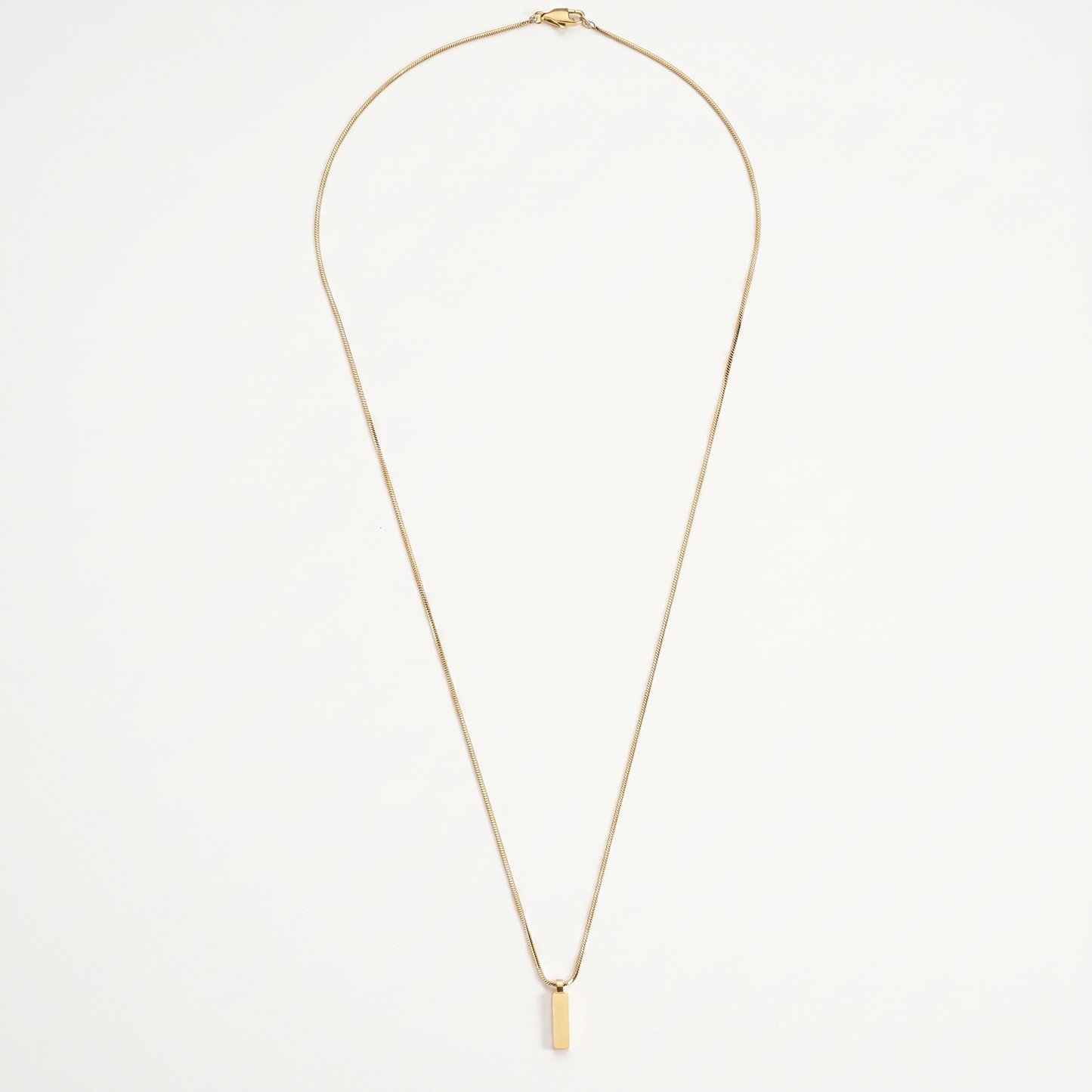 Gold bar pendant necklace on white
