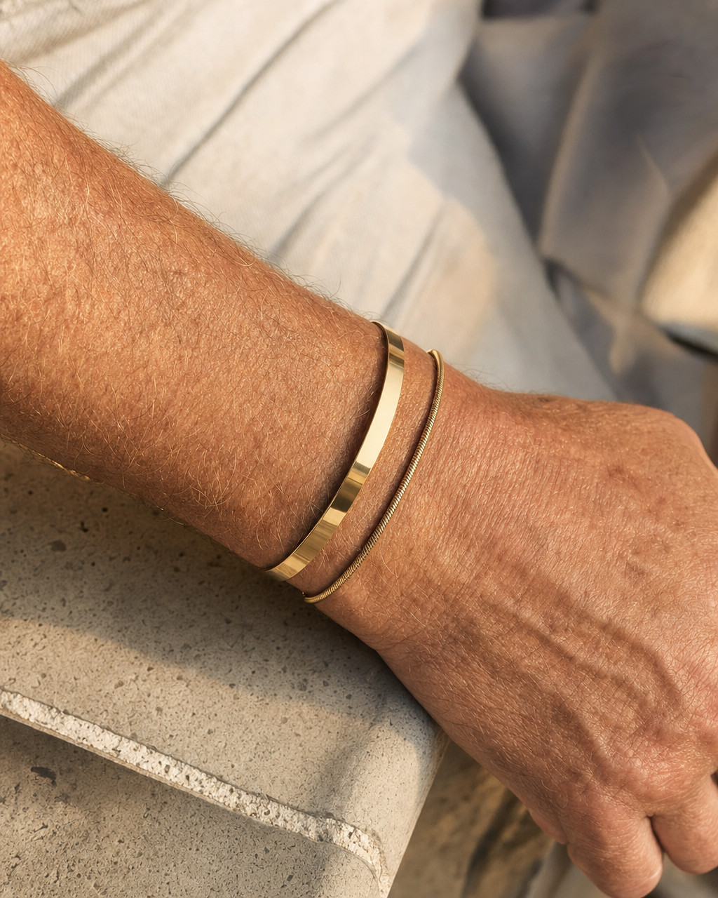 Meridian Cuff Gold worn alongside a gold chain bracelet