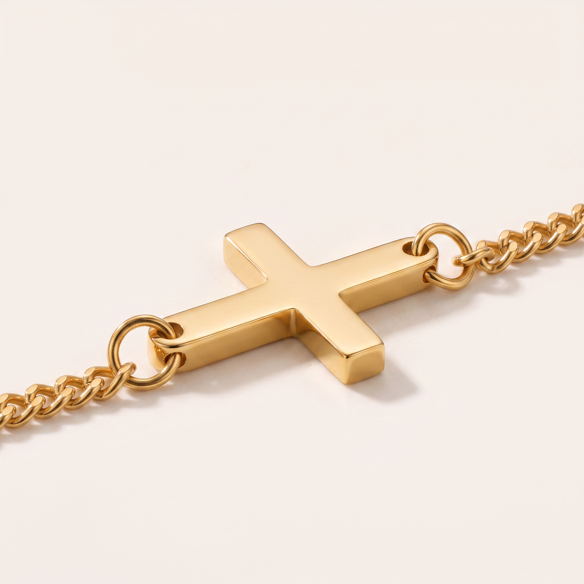 Close up of the cross and curb chain on the Cross Bracelet Gold