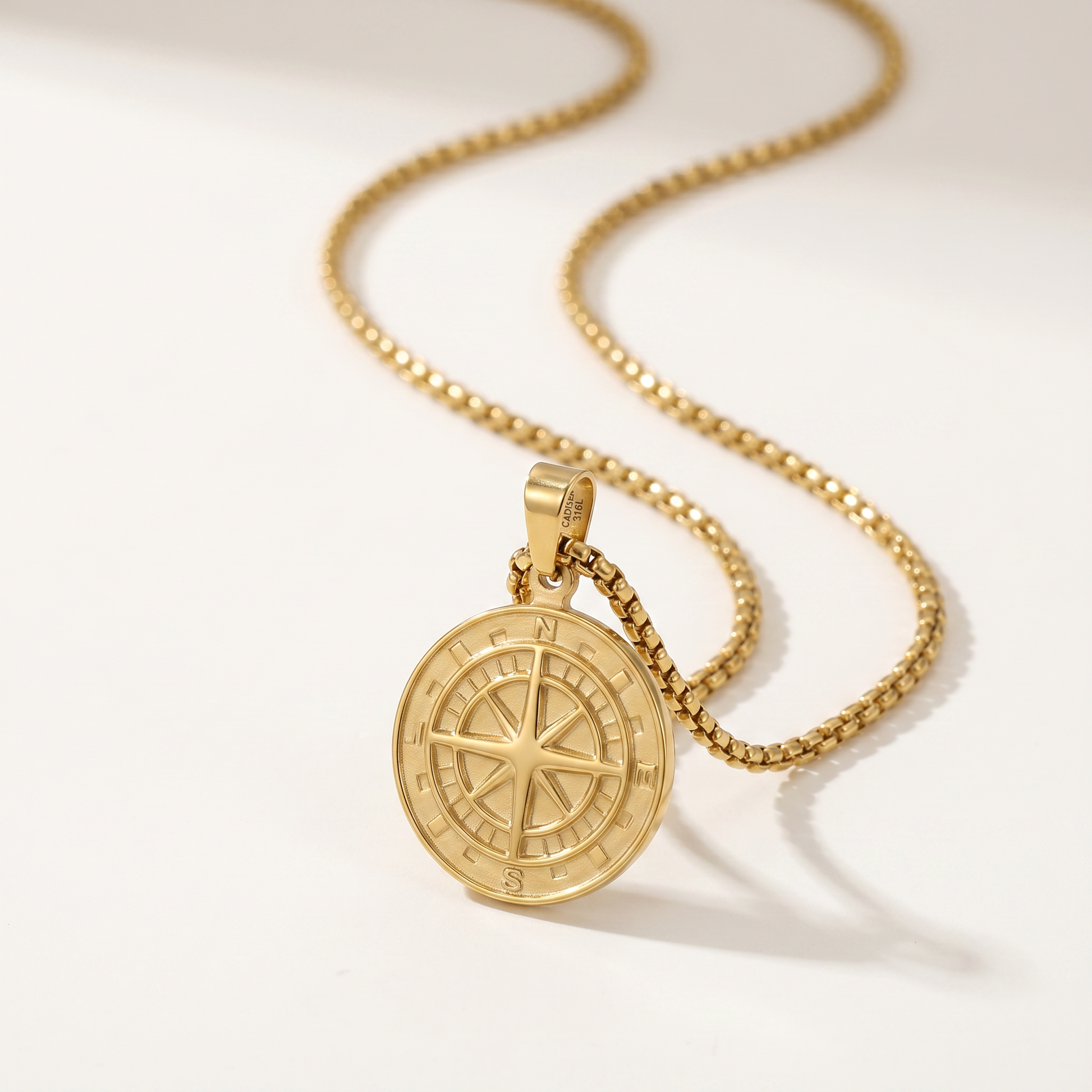 Close-up of the engraved compass medallion and box chain