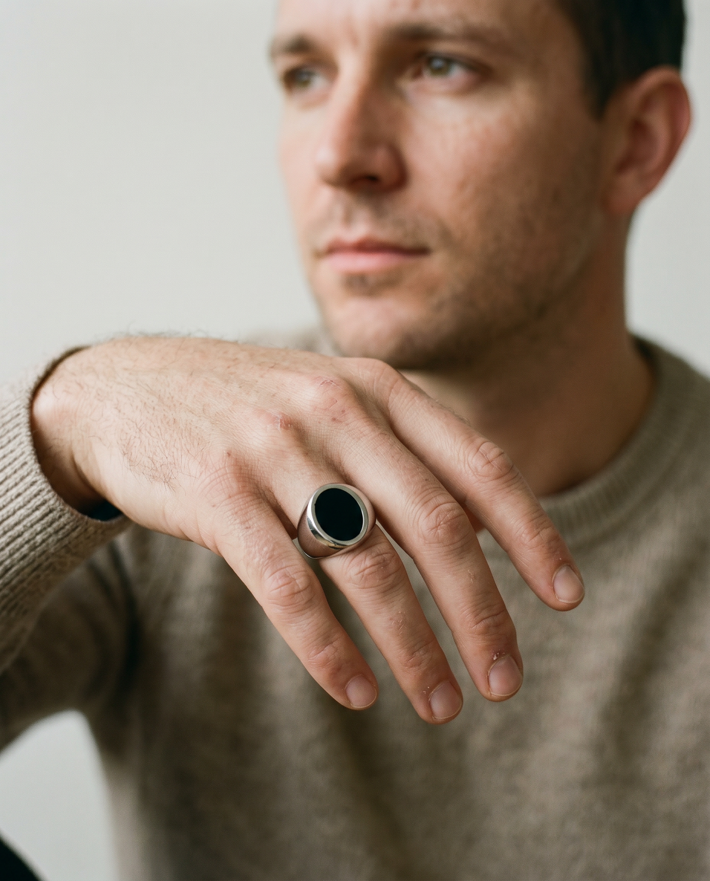 Round onyx signet ring worn on the hand