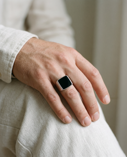 Square onyx signet ring worn on the hand